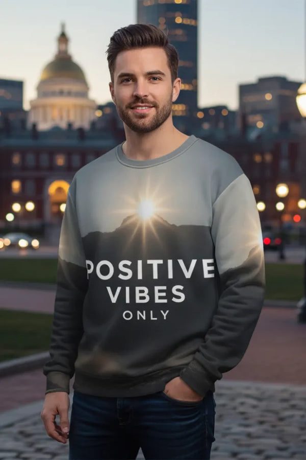 Man wearing a sweatshirt with 'Positive Vibes Only' text in an urban setting