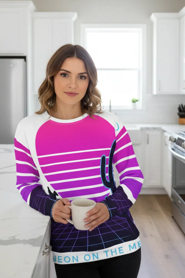 Woman wearing a colorful sweater with a cactus design in a kitchen.