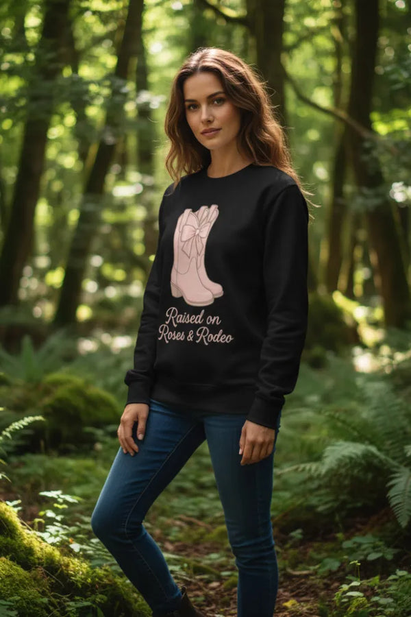 Woman wearing a black sweatshirt with a graphic design in a forest setting