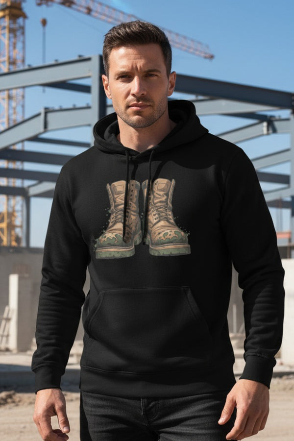 Man wearing a black hoodie with a graphic of boots in an industrial setting