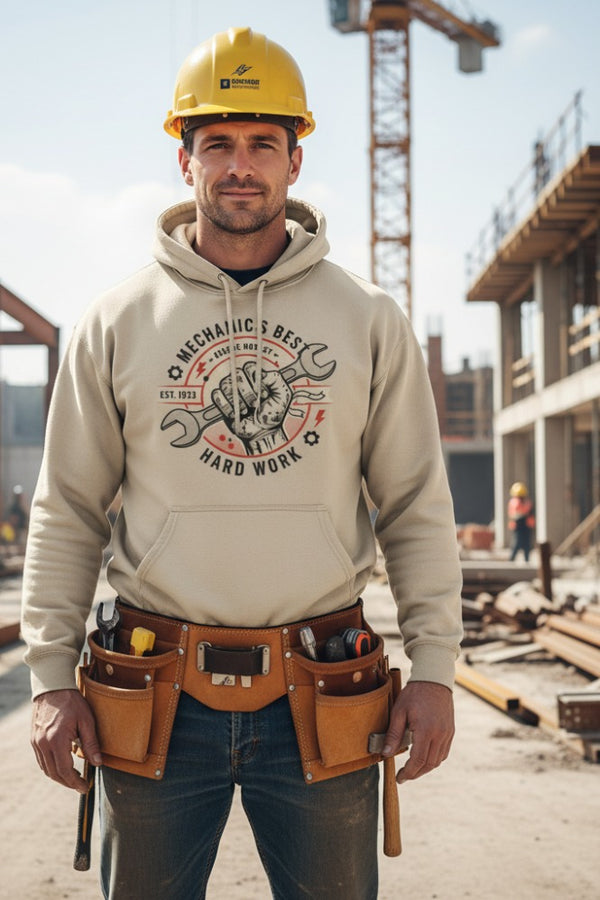 Man wearing a hoodie with a graphic design and tool belt on a construction site