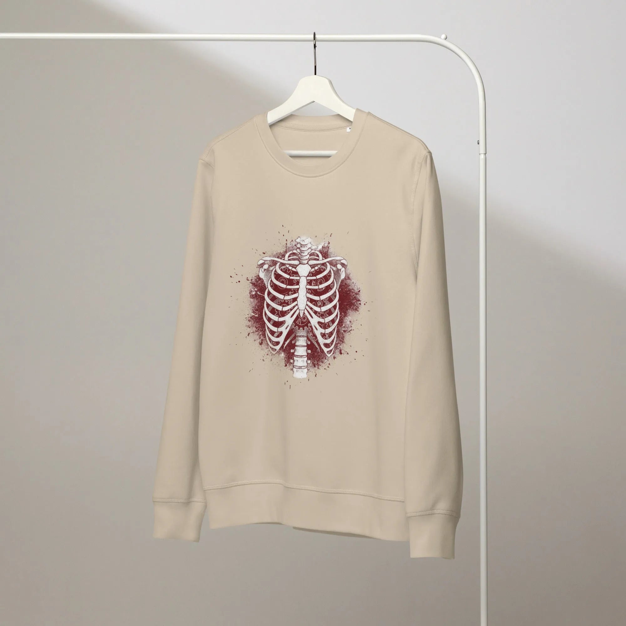 Close-up of a faded, anatomical heart print on a heather grey sweatshirt. A single thread is loose near the collar.