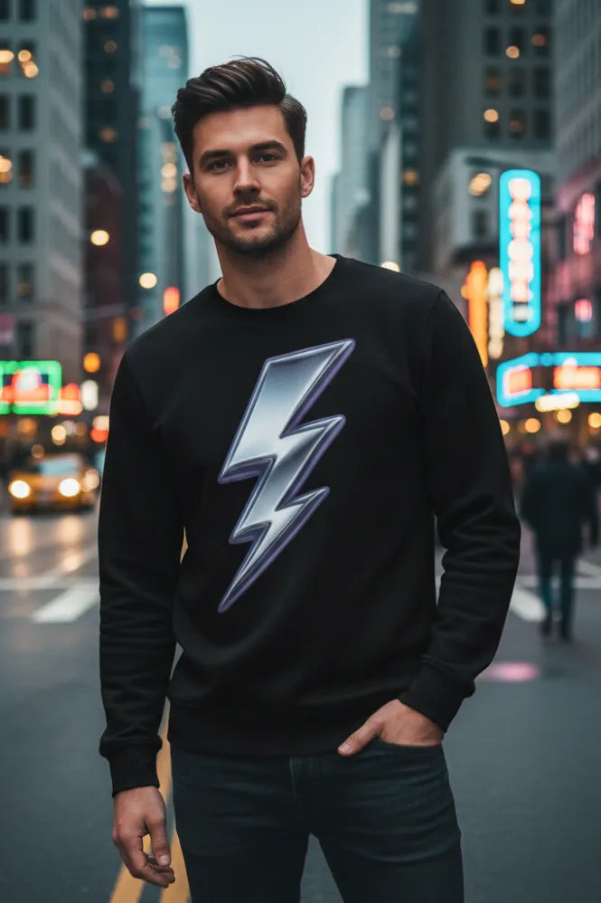 Man in black sweatshirt with chrome lightning bolt graphic, standing on a city street at night.