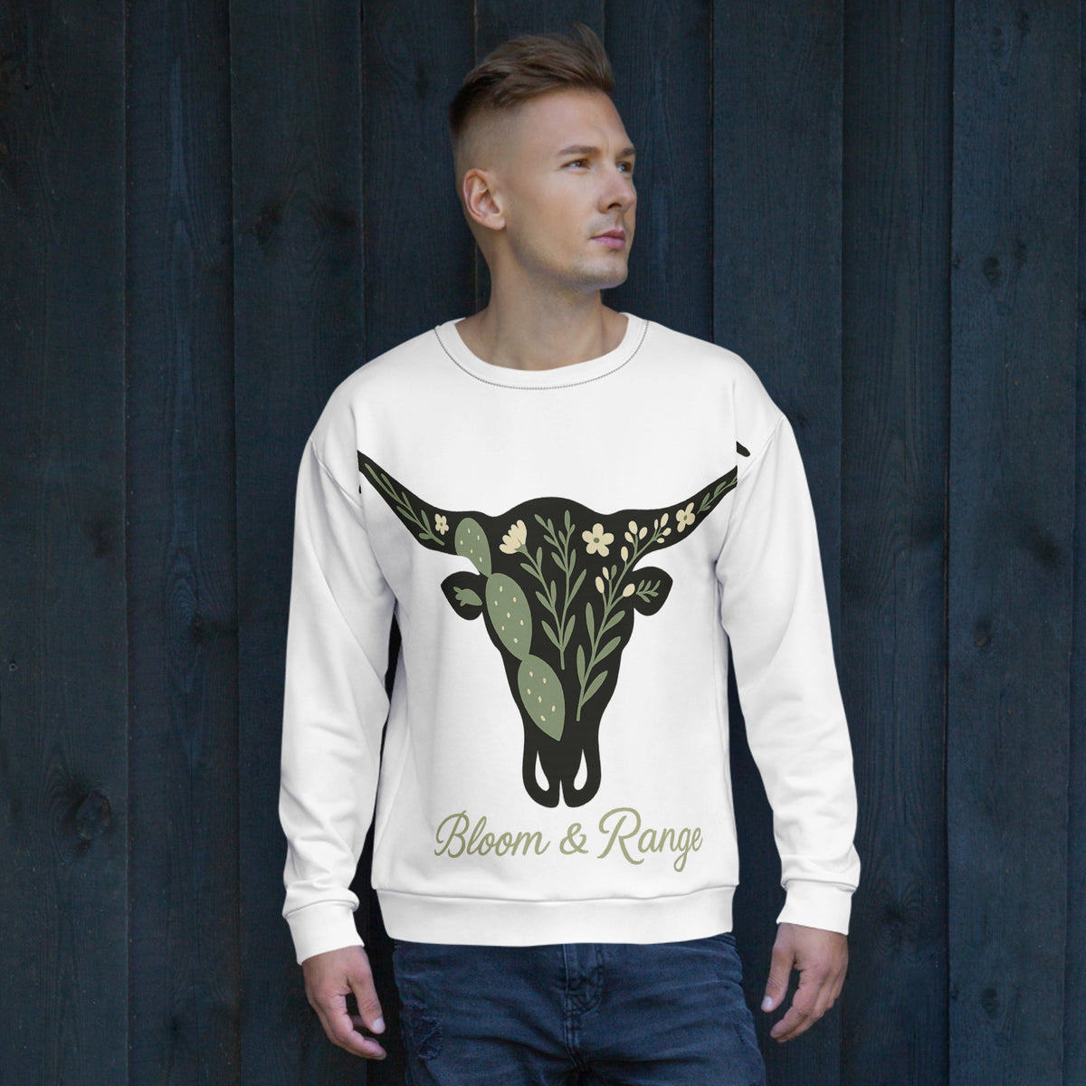 Man wearing a white sweatshirt with a bull skull design and 'Bloom & Range' text against a dark wooden background.