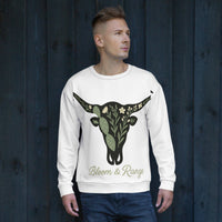 Man wearing a white sweatshirt with a bull skull design and 'Bloom & Range' text against a dark wooden background.