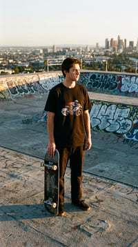 Phantom Speed Rider Graphic GOTS-certified organic cotton tee worn in a rooftop skatepark — 90s retro sustainable