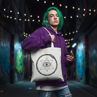 Person with green hair holding a tote bag with a symbol in a graffiti-covered alley.