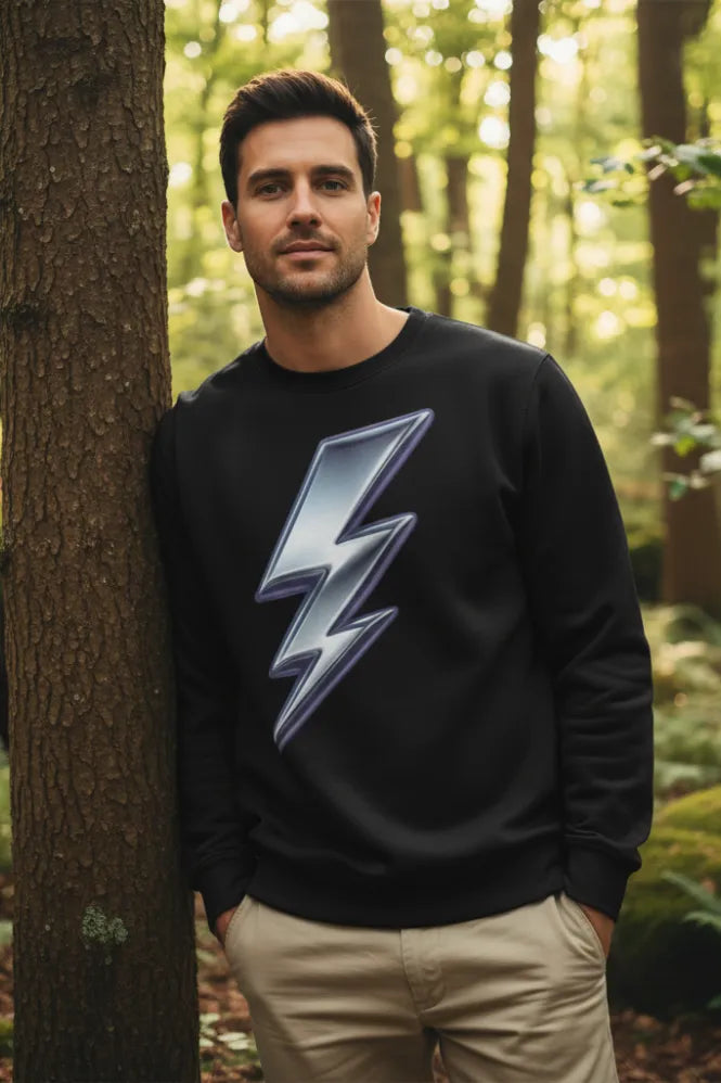 Man wearing a black sweatshirt with a lightning bolt design in a forest setting