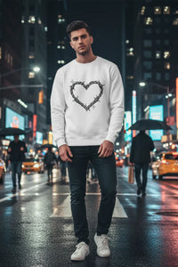 Man wearing a white sweatshirt with a heart design on a city street at night.