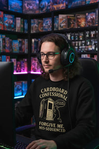 Person wearing a headset and black sweatshirt with text in a room filled with shelves of video games.