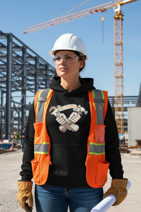 Person wearing a hard hat, safety glasses, and an orange safety vest on a construction site.