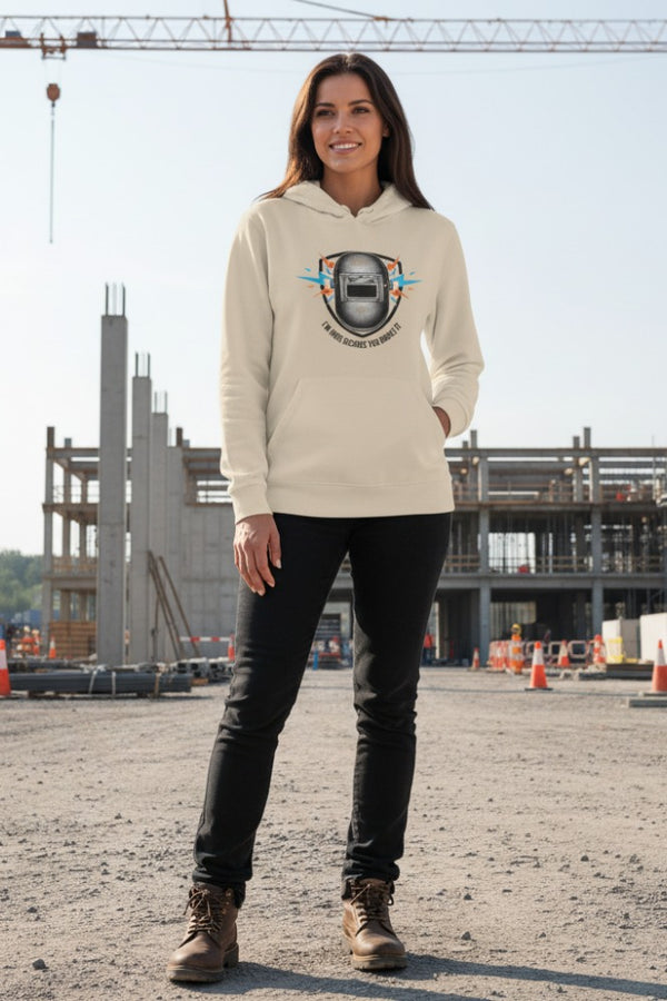 Woman wearing a beige hoodie with a graphic design in an outdoor setting