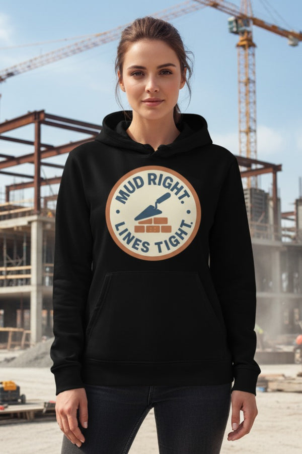 Woman wearing a black hoodie with a logo and text, standing in front of construction equipment.