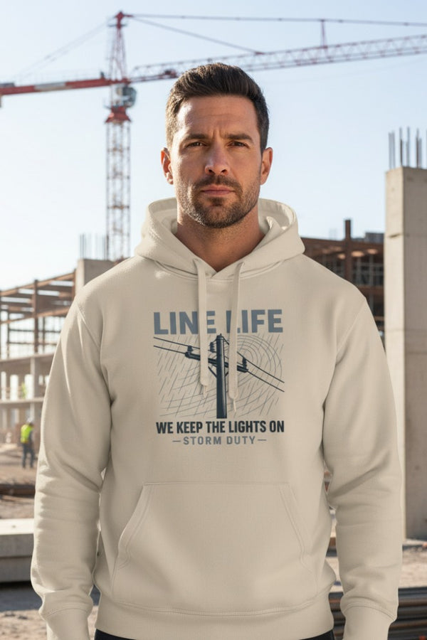 Man wearing a hoodie with 'Line Life' and 'We Keep the Lights On' text, standing in front of a construction site.
