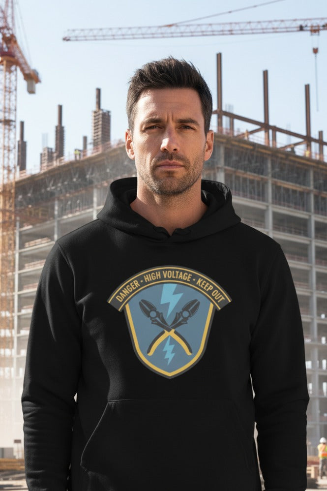 Man wearing a black hoodie with a logo in front of a construction site