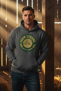 Man wearing a hoodie with 'Farm Strong' logo in a barn setting
