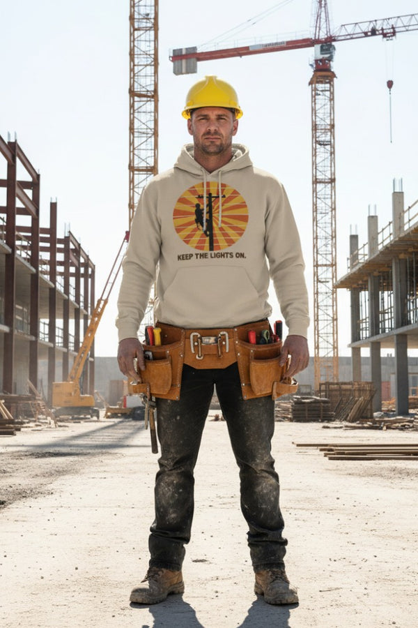 Person wearing a hoodie with a logo and text, standing on a construction site.