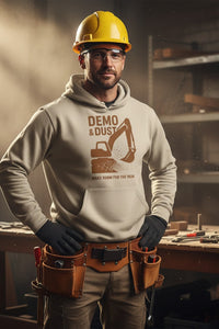 Man wearing a hard hat and work attire with a tool belt in a workshop setting