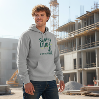 Man wearing a hoodie with text standing in front of a construction site